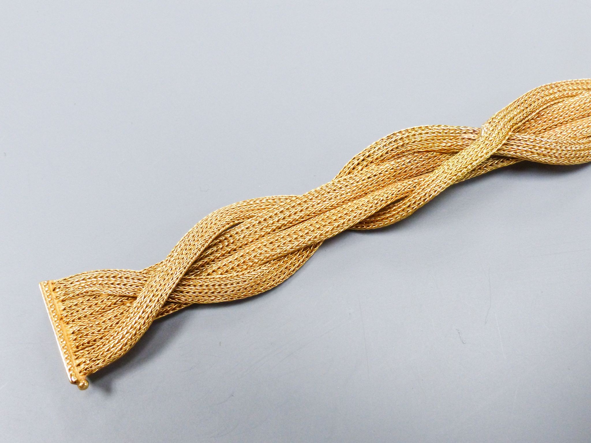 An 18ct gold plaited mesh bracelet, 19cm, 31 grams (repair).